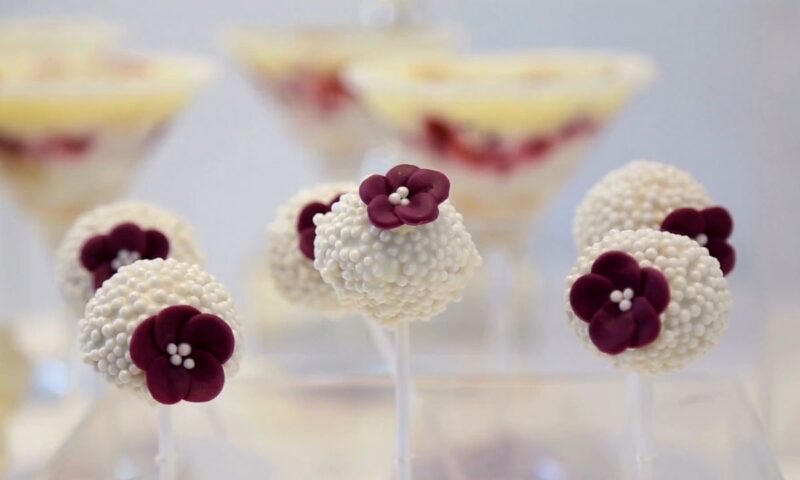 kapkejkovi bele boje uvaljani u bele ukrasne mrvice sa cvetićima ljubičaste boje